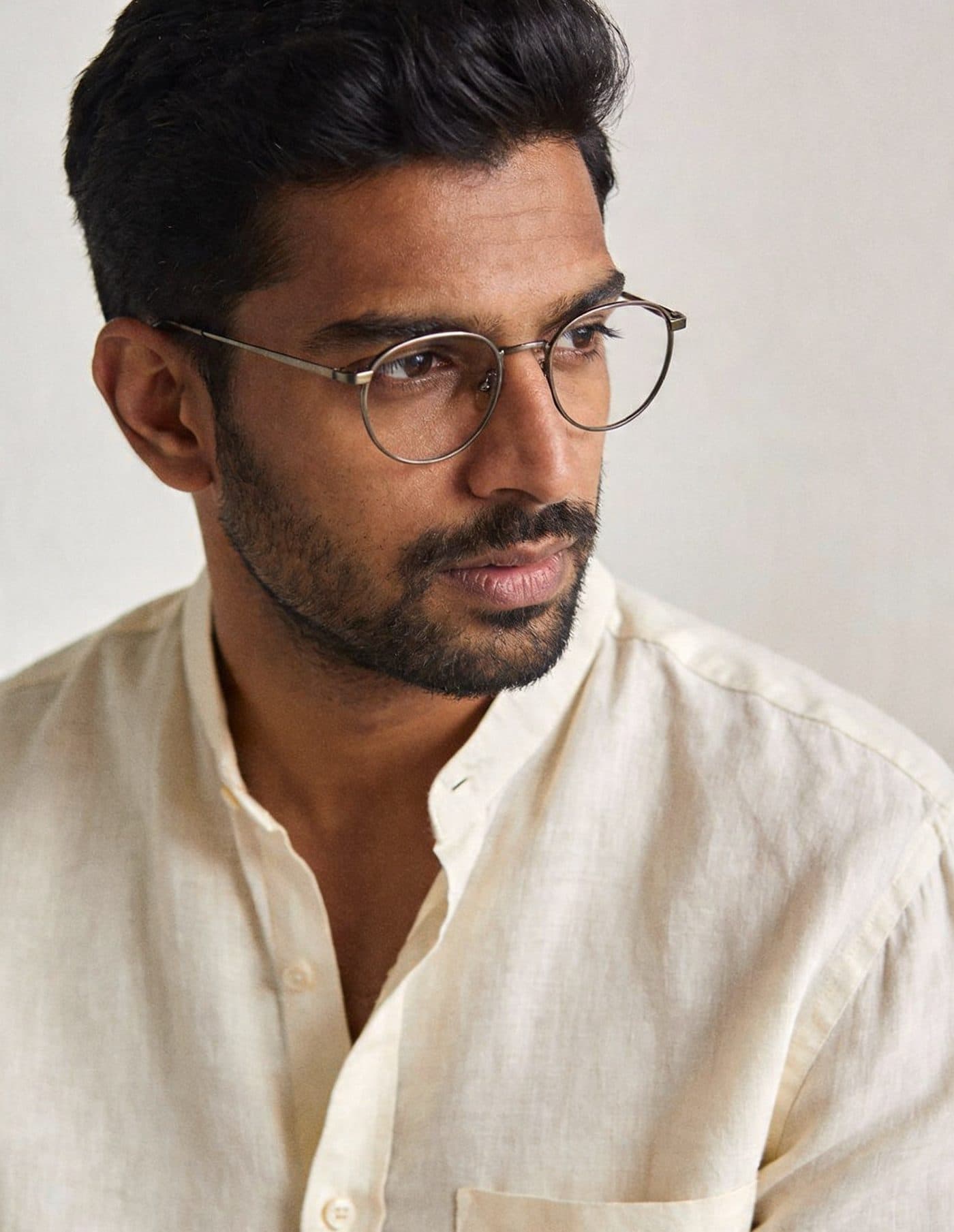 Premium titanium eyewear — hands unfolding a frame